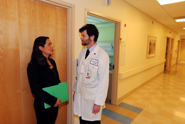 Dr. Sara Tartof and Dr. Bruno Lewin discuss vaccine research in hallway at the Los Angeles Medical Center