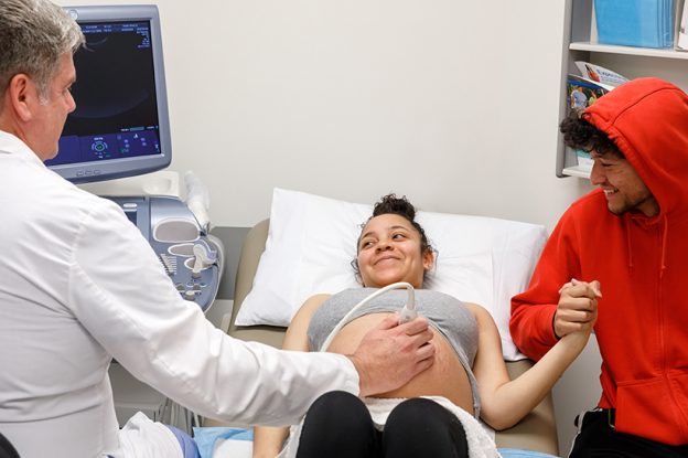 Kaiser Permanente Dr. Michael Fassett examines pregnant patient.